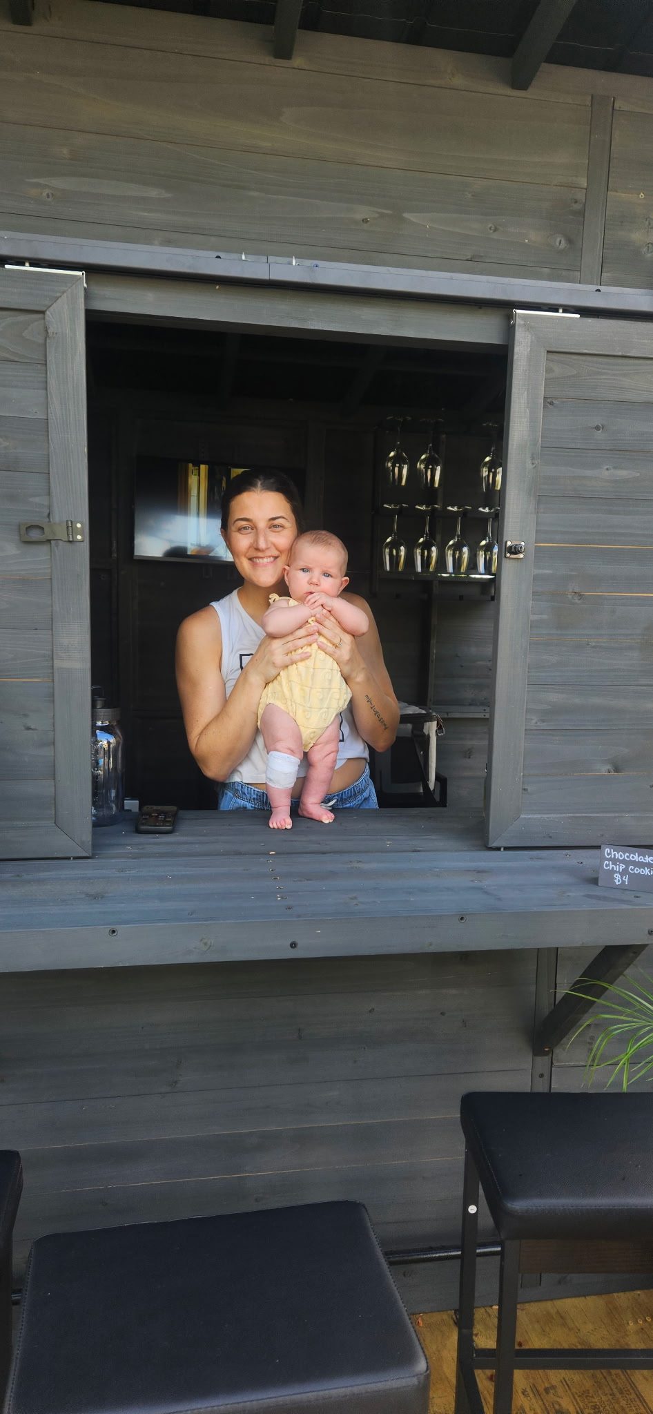 The Black Wren founder holding her baby in the stand window